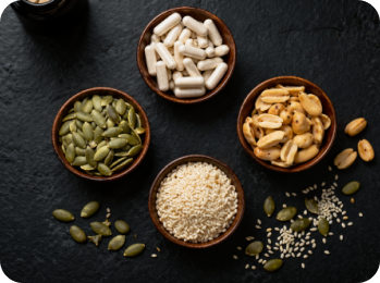 A pile of dried roots and a small bowl of powder sit on a wooden surface.