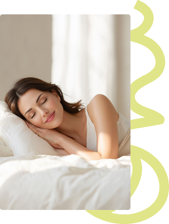 A woman with a serene expression sleeps in a brightly lit bed with white sheets and pillows.