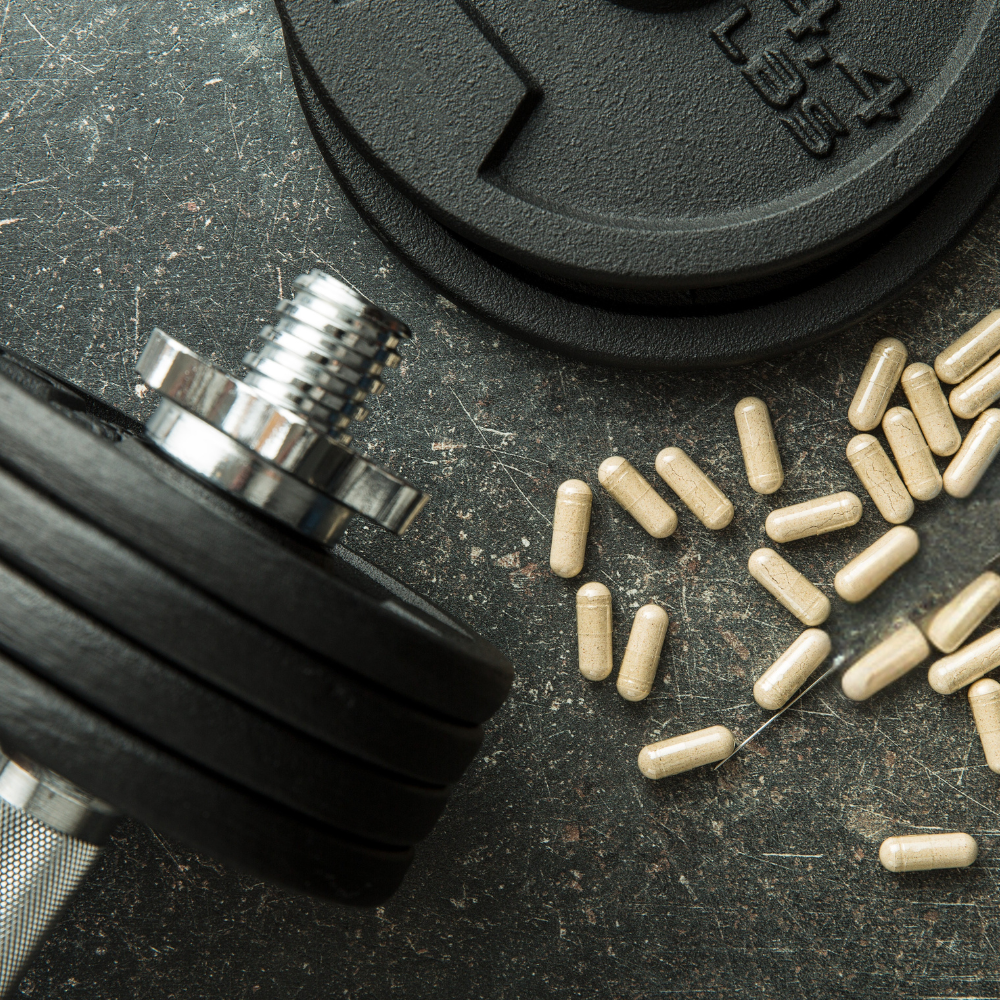 Close-up of a dumbbell and capsules on a textured surface.