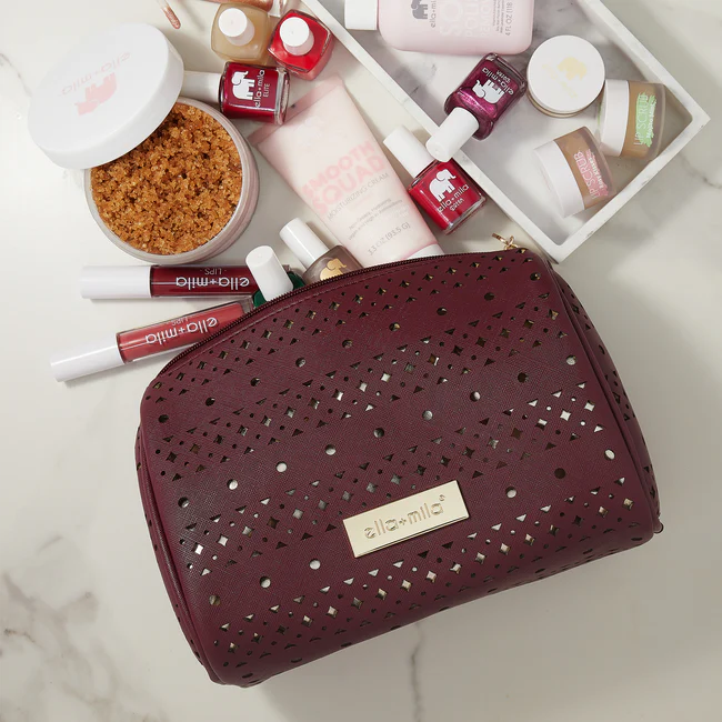 Cosmetic bag with skincare products and nail polishes on a marble surface.