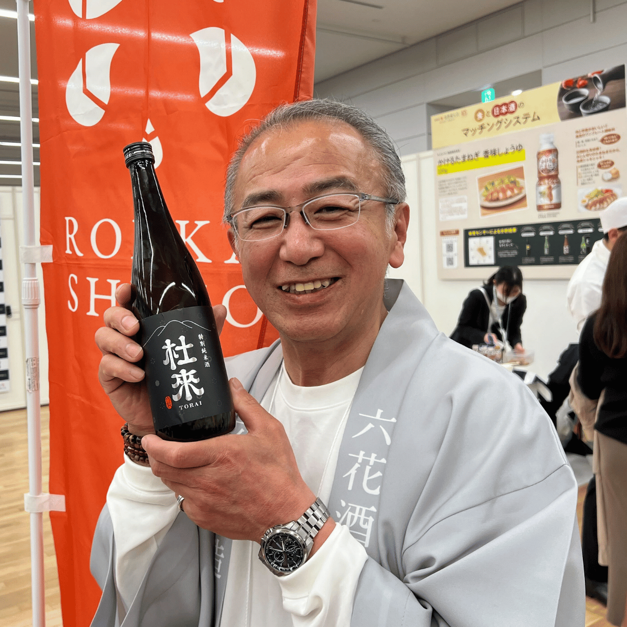 Tomonobu Ose of Rokka Brewing Company holding a bottle of Torai