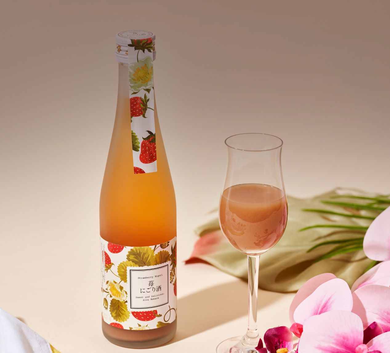 Two bottles of sake on a wooden table with roses, heart-shaped cookies, and a letter.