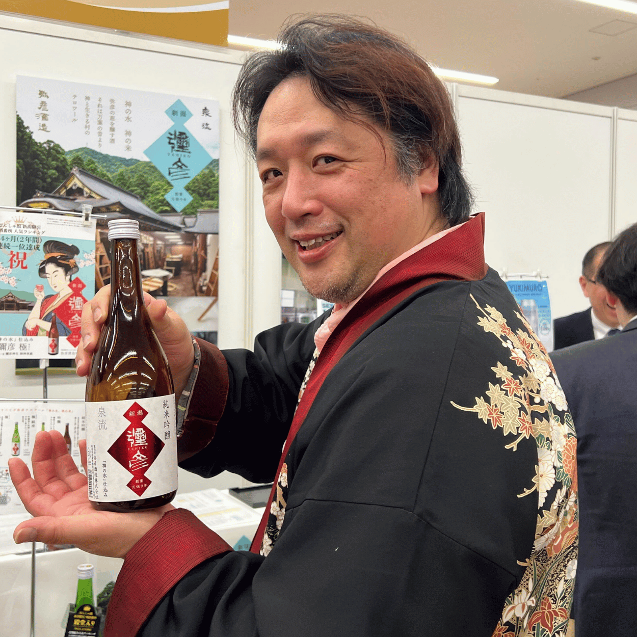 Brewmaster Genichiro Ooi of Yahiko Brewing Company holding a bottle of Izumiryu Yahiko