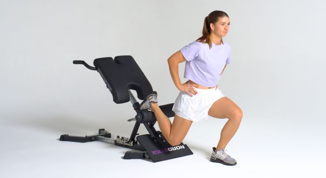 Person exercising with a Nordic track machine, performing a lunge.