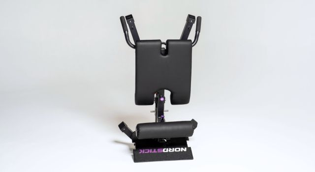 Black exercise equipment with padded supports on a white background.