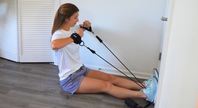 Woman exercising with resistance bands attached to a door.