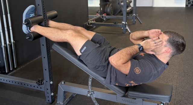 Man exercising on an incline bench in a gym.