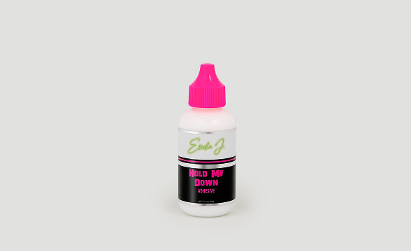 A white bottle of Hold Me Down Adhesive with a bright pink cap against a light grey background.