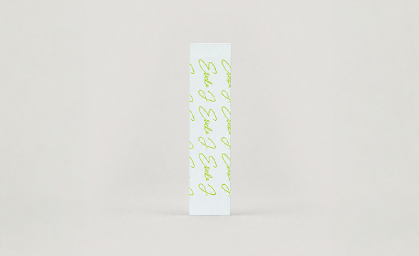 A thin white box with a repeating lime green signature pattern standing against a plain background.