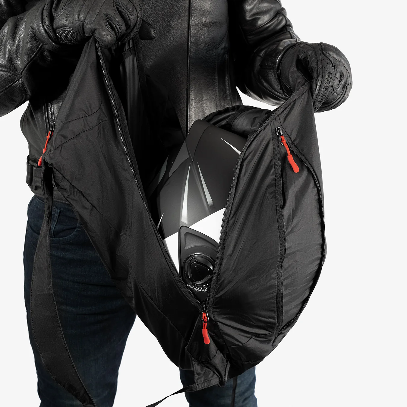 Person holding a black bag with a helmet inside.