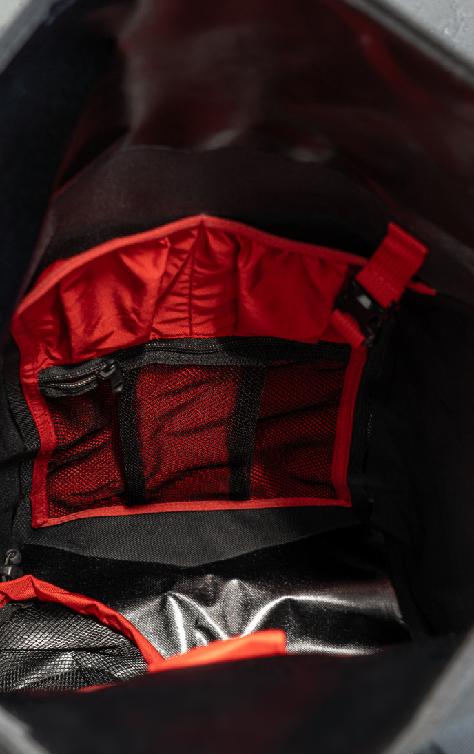 Inside view of a backpack with red and black interior pockets.