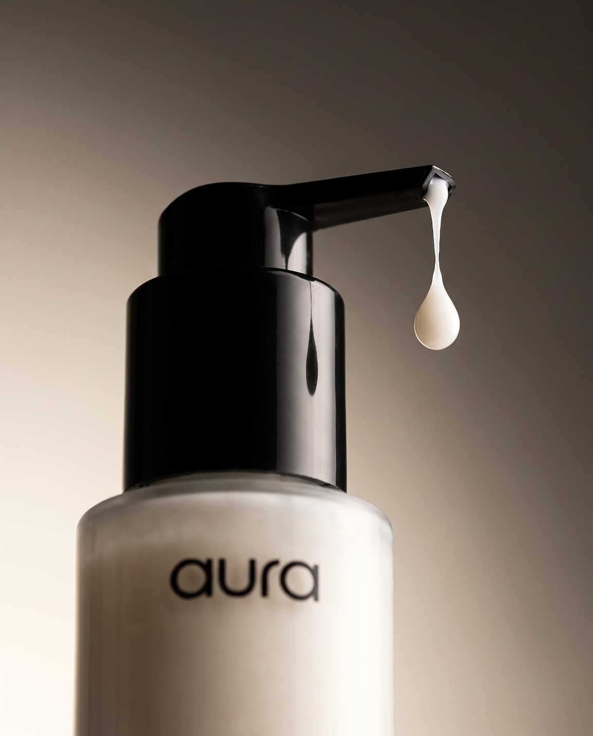 A woman with wet hair holds a clear bottle of Aura shampoo against her chest.