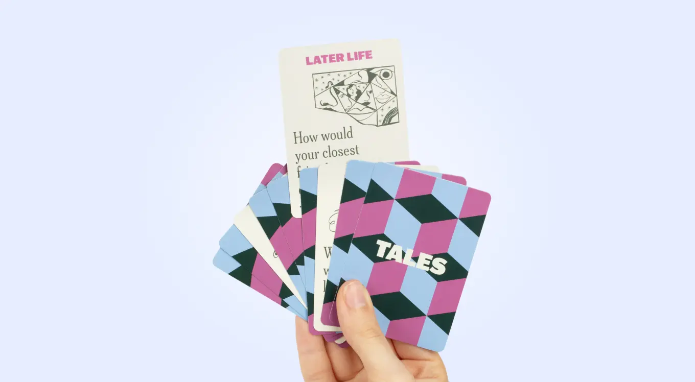 Hand holding colorful cards with geometric patterns and text.