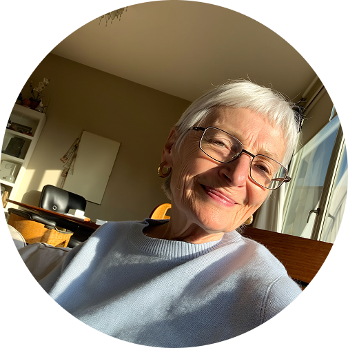 Elderly woman with glasses smiling in a sunlit room.