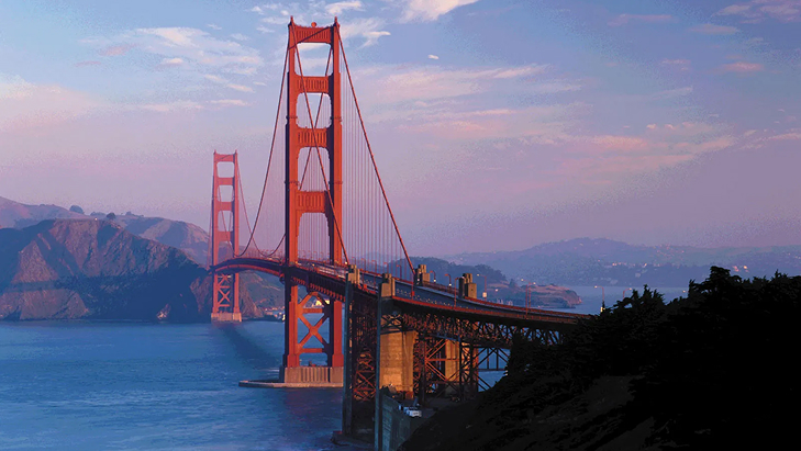 Golden Gate Bridge at sunset with a clear sky.