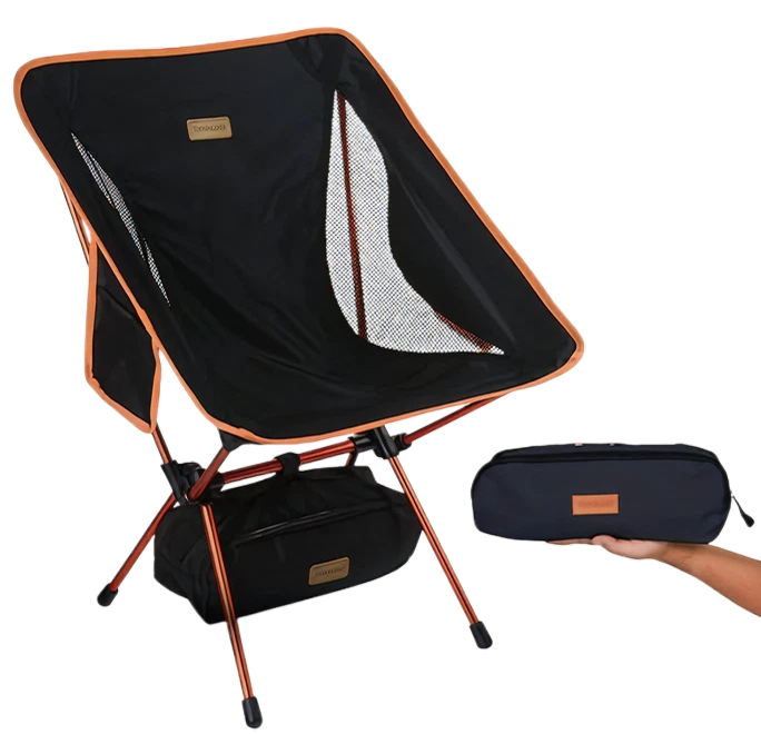 A black and orange portable camping chair shown next to a hand holding its carrying case.