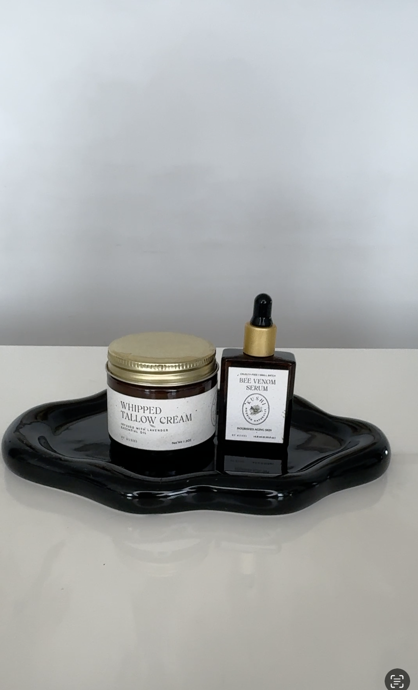 Cream and serum bottles on a black tray.