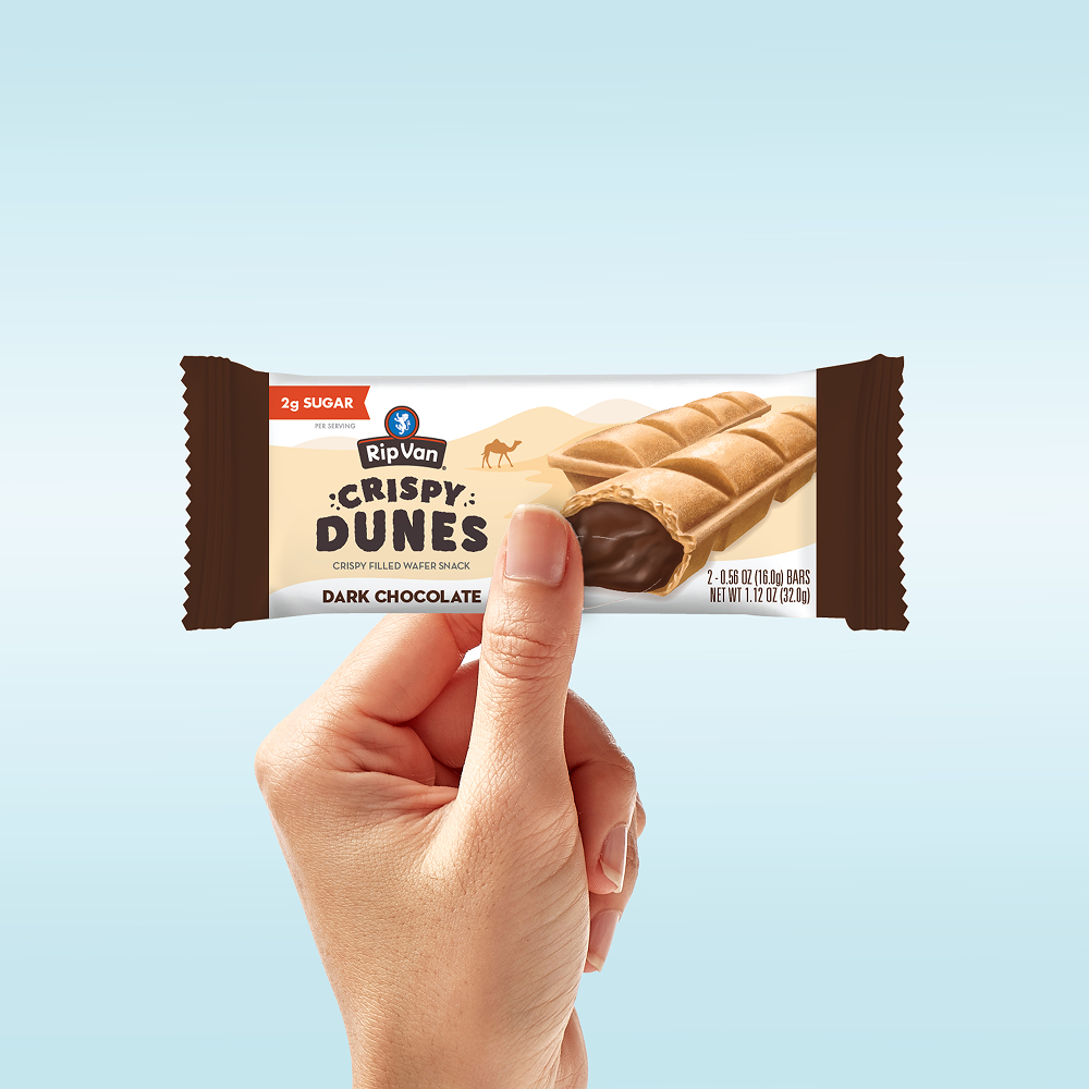 Hand holding a Rip Van Crispy Dunes dark chocolate wafer snack.