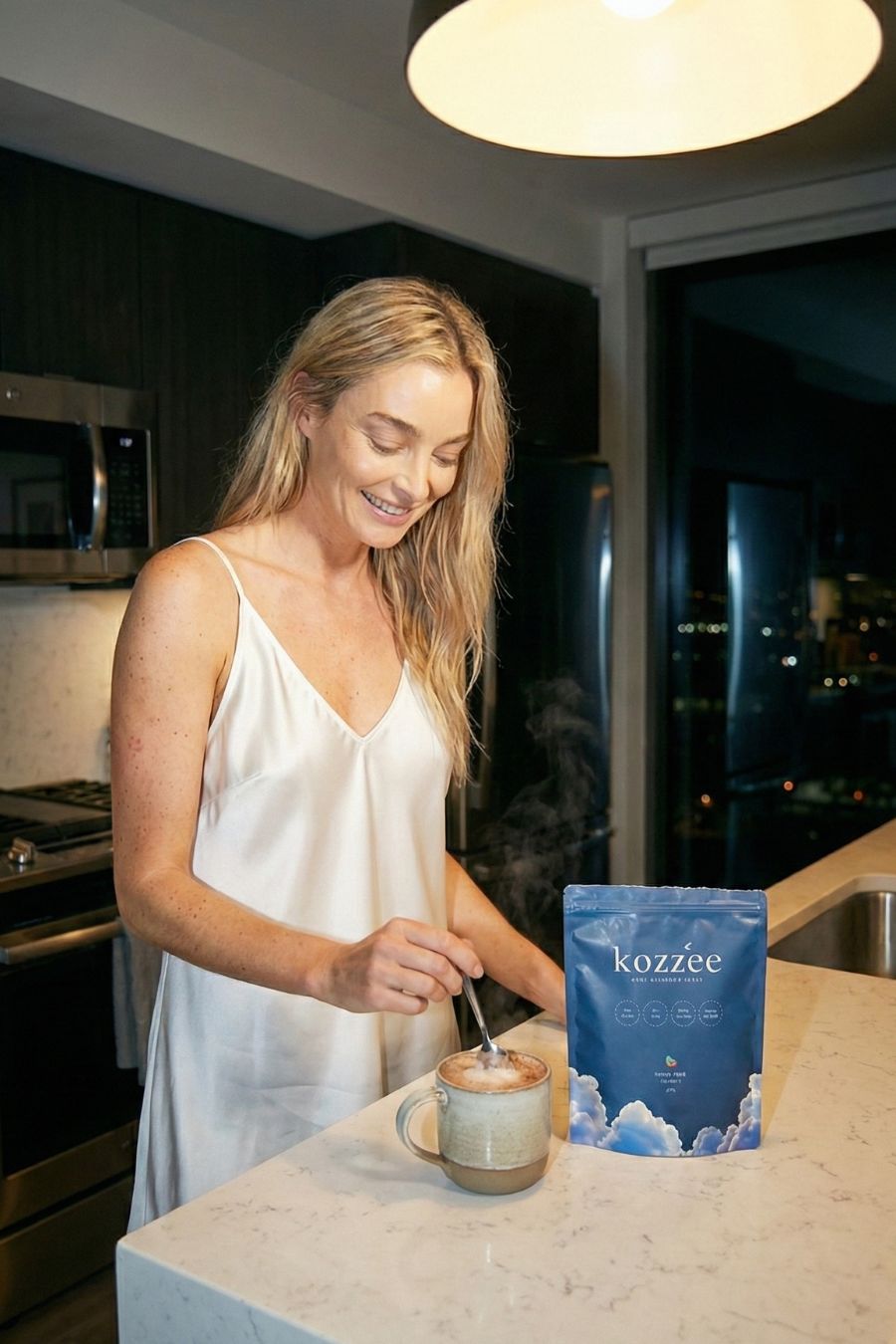 Person in kitchen stirring a mug beside a package labeled 'kozzee.'