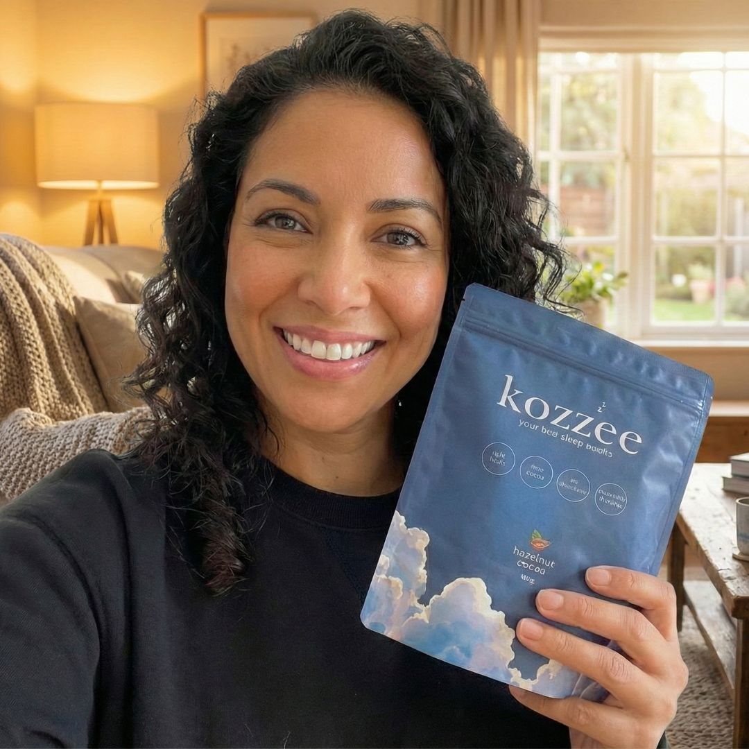 A smiling woman with dark curly hair holds up a blue pouch of Kozzee sleep benefits product.