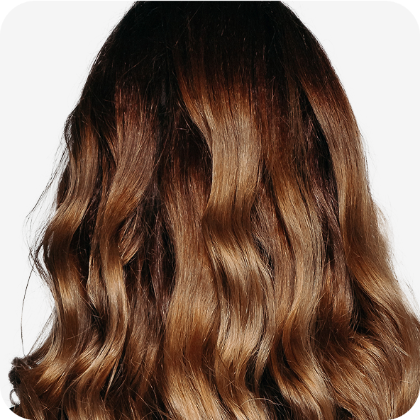 Wavy brown hair viewed from the back against a plain background.