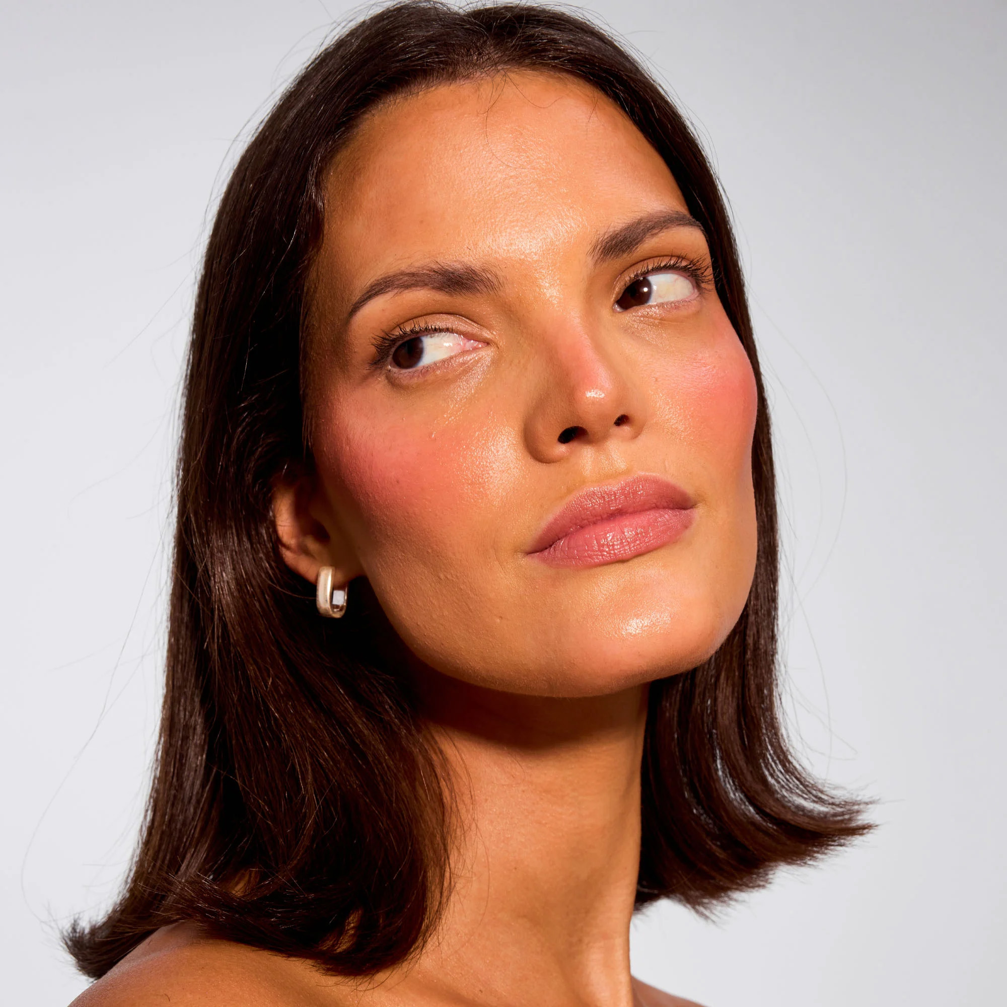 Gorgeous model with medium-tan skin showcasing that The Glow Trio works on all skin tones. 