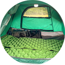 Interior of a green tent with gear and a light inside.