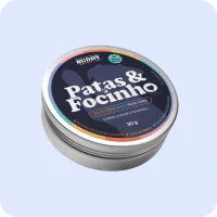A round, silver tin of Buddy 'Patas & Focinho' moisturizer for dogs on a light blue background.