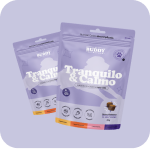 Two purple pouches of Buddy 'Tranquilo & Calmo' dog treats against a light purple background.