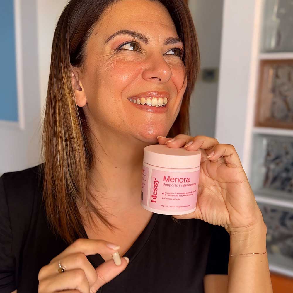 Smiling woman holding a jar labeled 'Menora' and a small capsule.