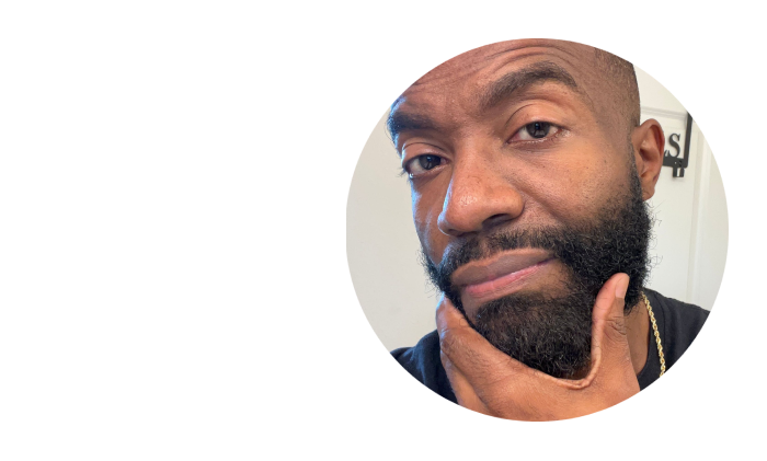 A person with a beard touching their chin, looking thoughtful.