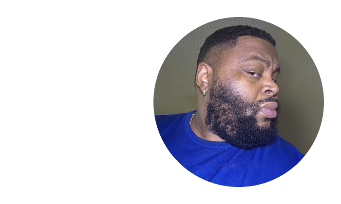 Man with a beard in a blue shirt, looking to the side.