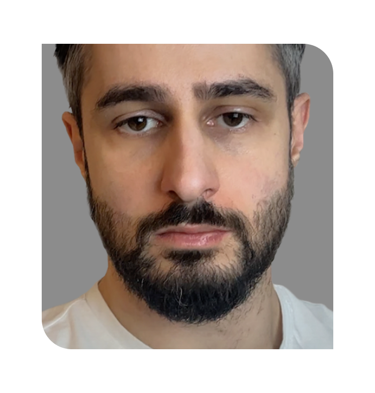 Close-up of a man with a beard and neutral expression.