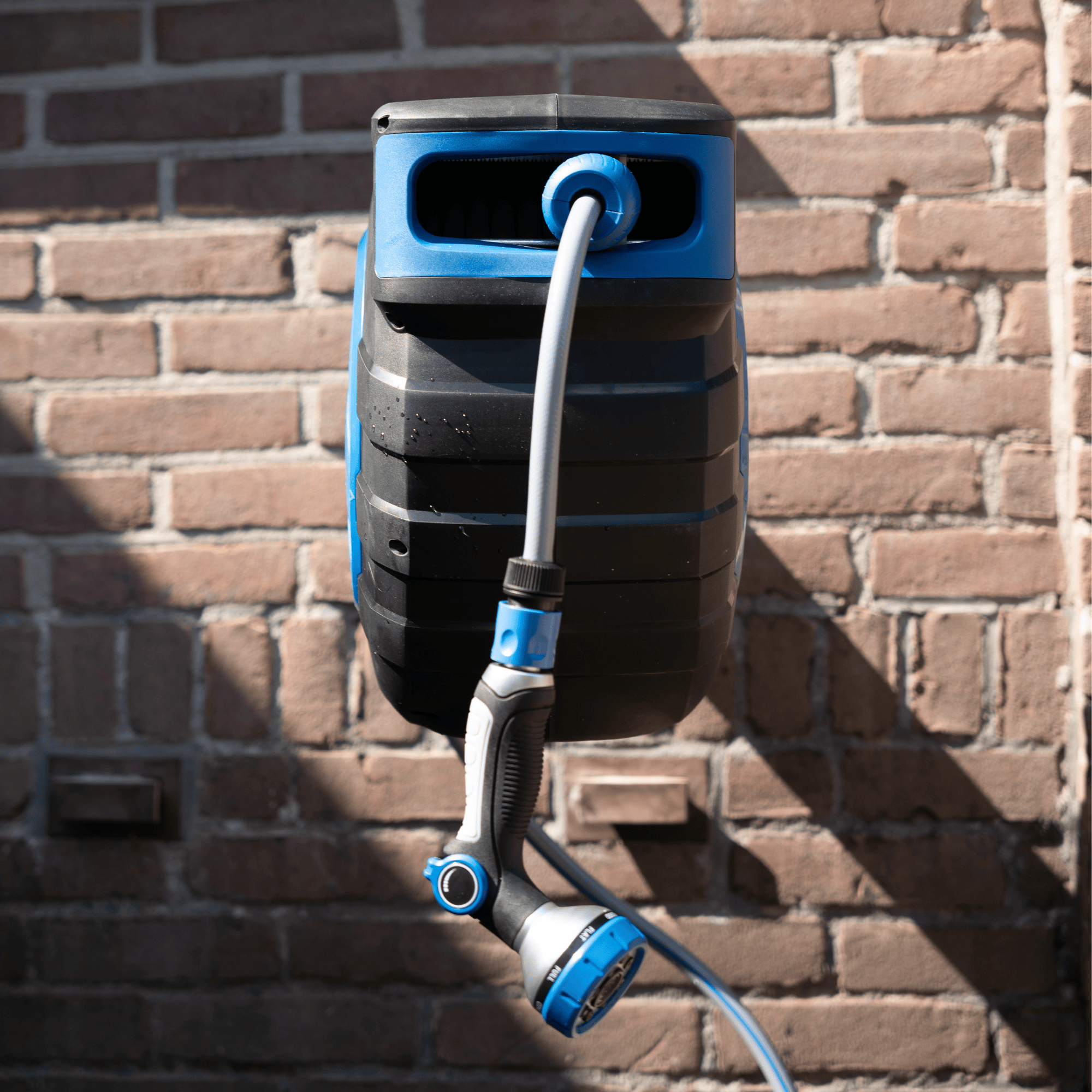 Wall-mounted garden hose reel with a blue and black design.