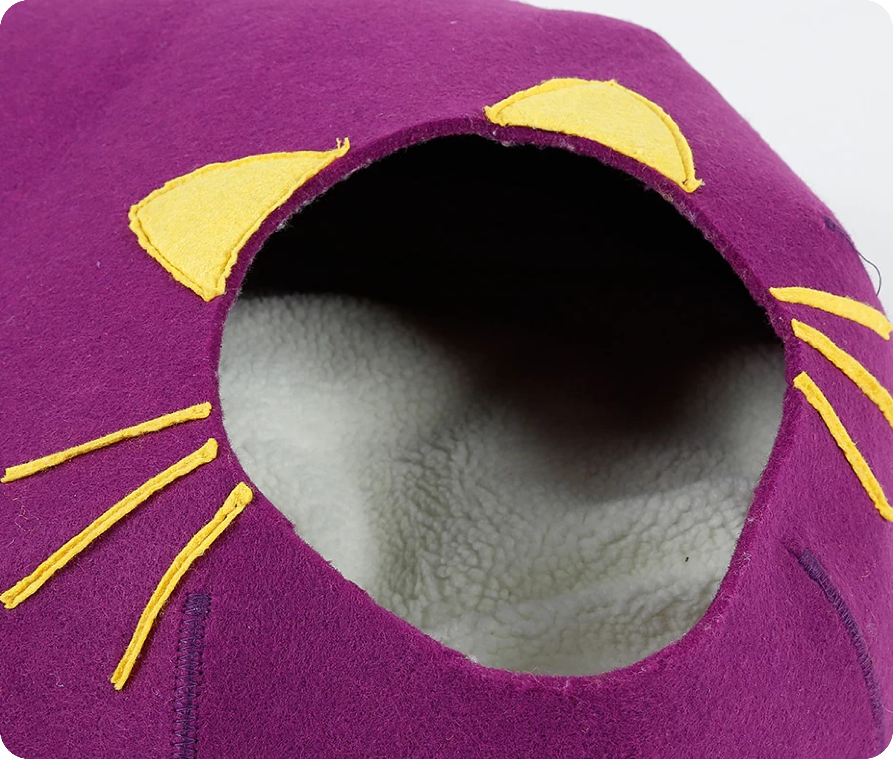 Purple cat-shaped pet bed with yellow ears and whiskers.