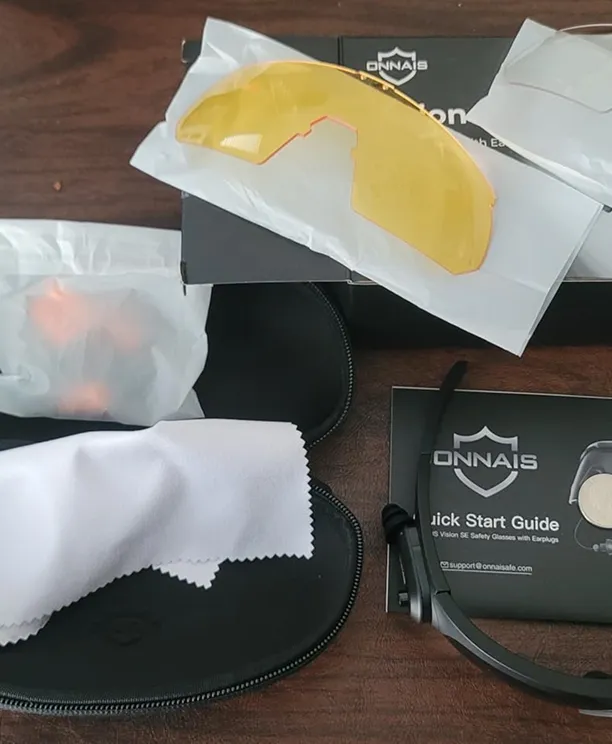 A pair of Onnais safety glasses with an interchangeable yellow lens, a case, and a cleaning cloth.