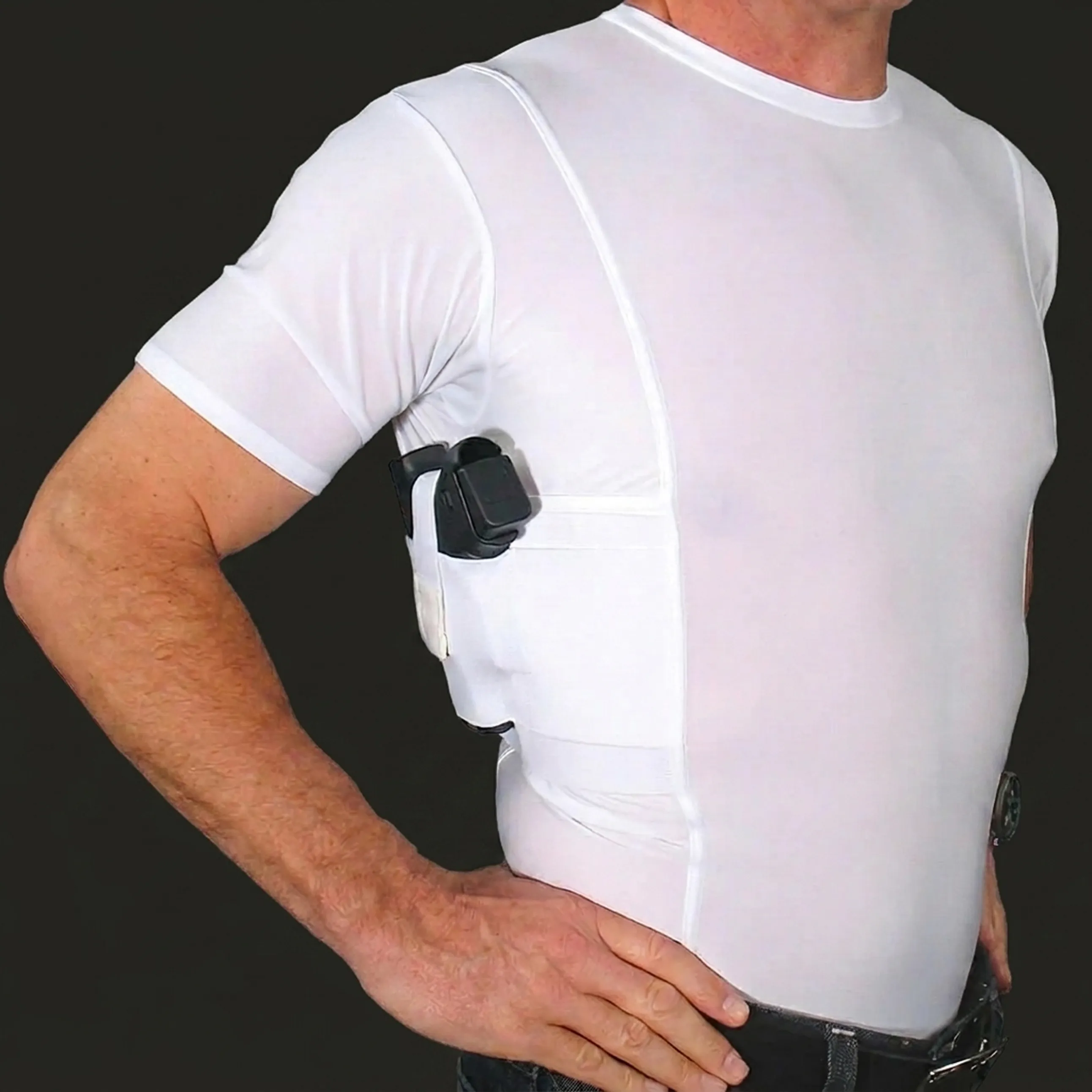 A man wearing a white t-shirt with a built-in underarm holster holding a handgun.
