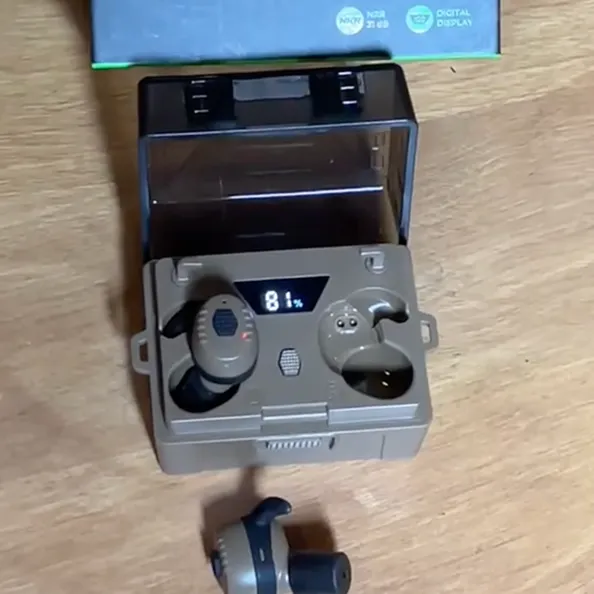 Wireless earbuds in a charging case with digital display, one earbud outside.