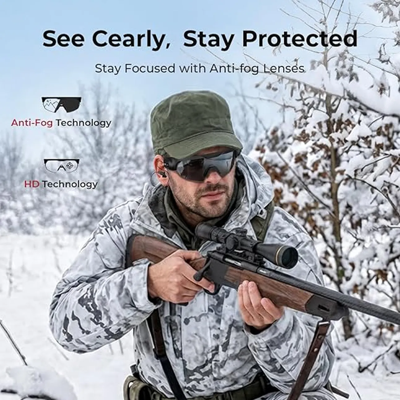 A man in winter camouflage and protective glasses holds a rifle with a scope in a snowy forest.