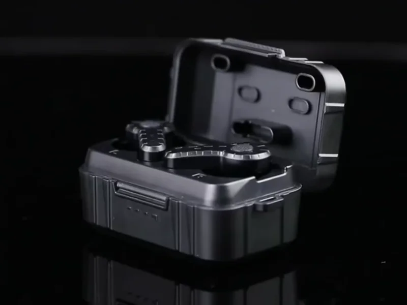 Black storage case with open lid and internal compartments on a reflective surface.