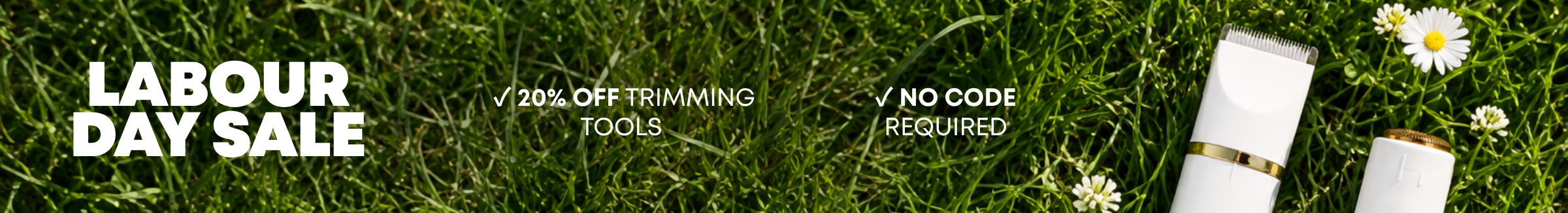 A Labour Day Sale banner with two white trimming tools lying on green grass with white flowers.
