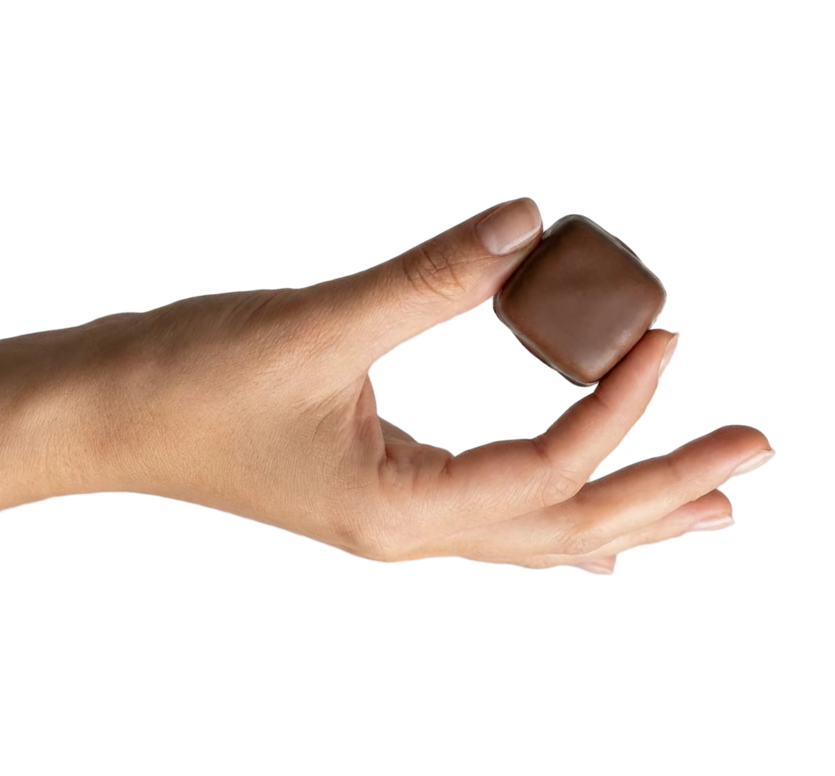 A hand holding a single, square piece of milk chocolate against a green background.