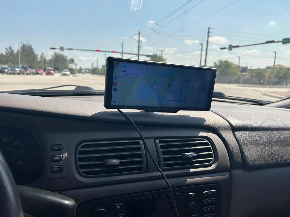 Smartphone with navigation app on car dashboard.