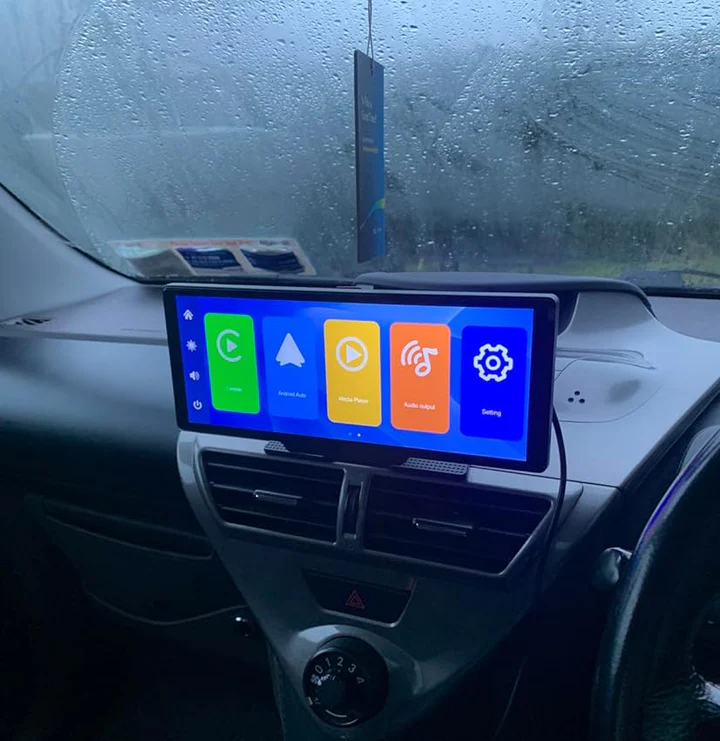 Car interior with a digital touchscreen display showing colorful icons.