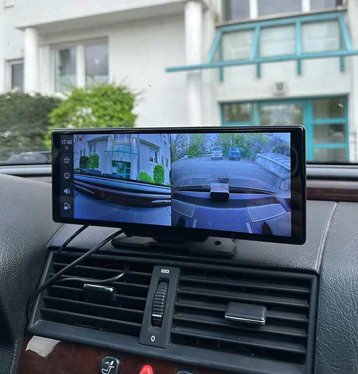Car dashboard with a split-screen display showing rear and side camera views.
