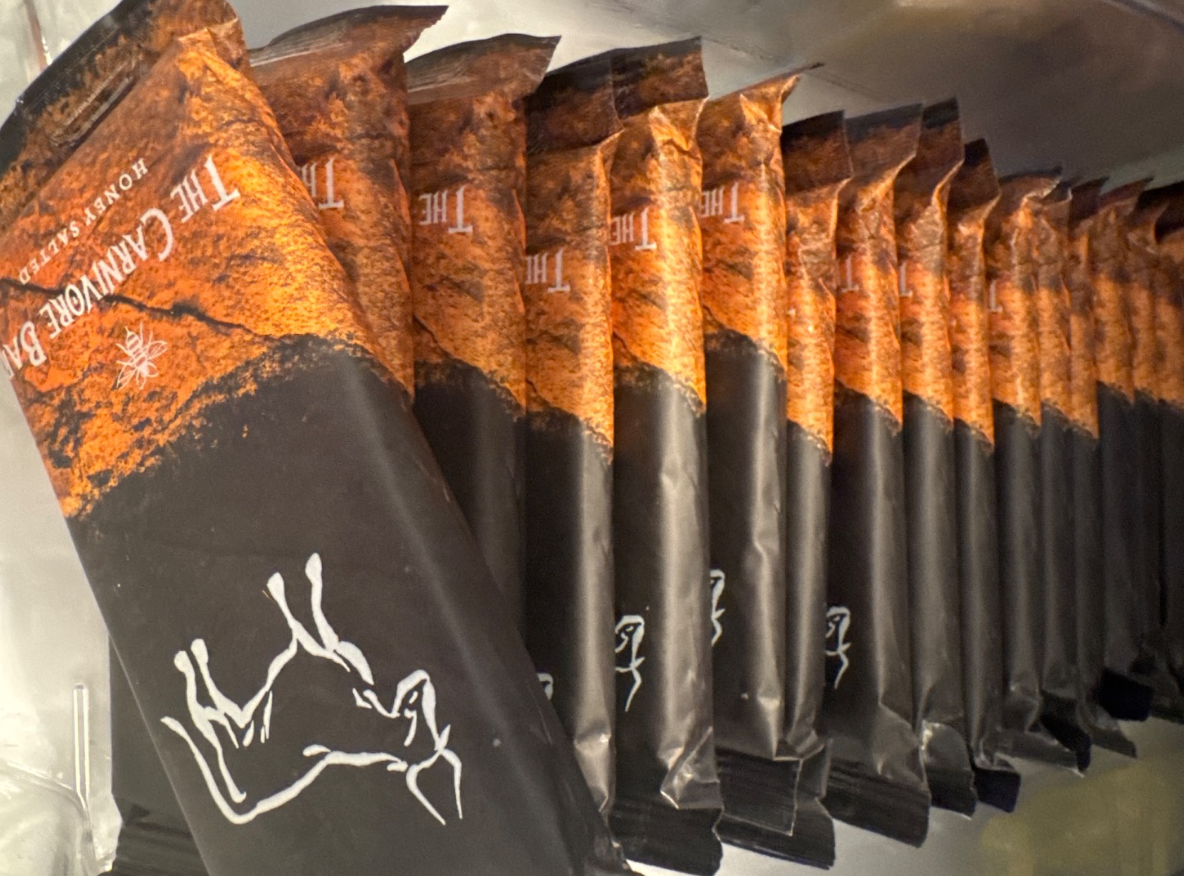 A row of Honey Salted flavored The Carnivore Bar packages lined up on a shelf.