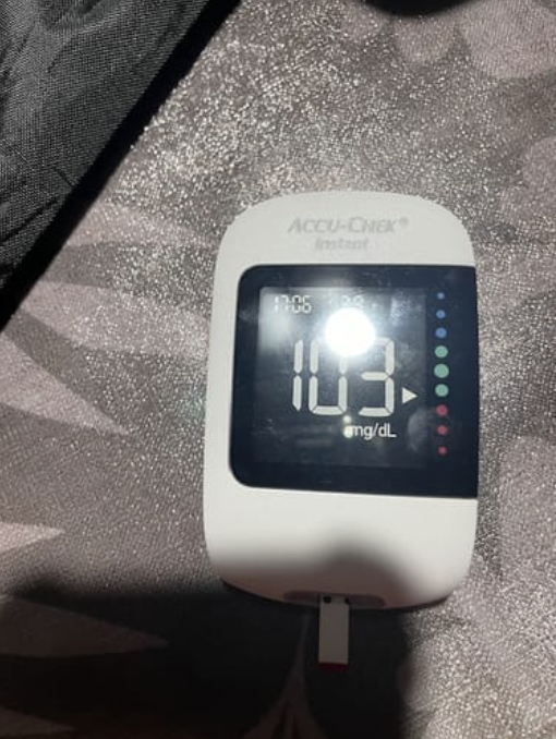 Accu-Chek glucose meter displaying a reading of 103 mg/dL.