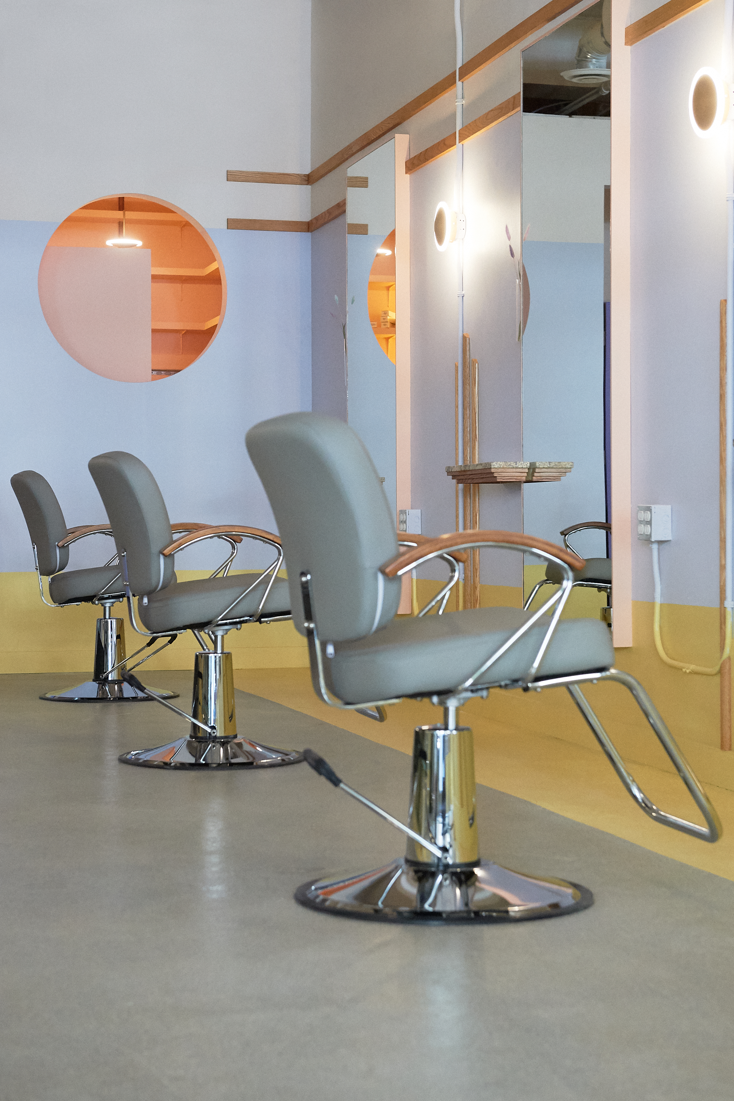 Three salon chairs in a modern, minimalist hair salon.