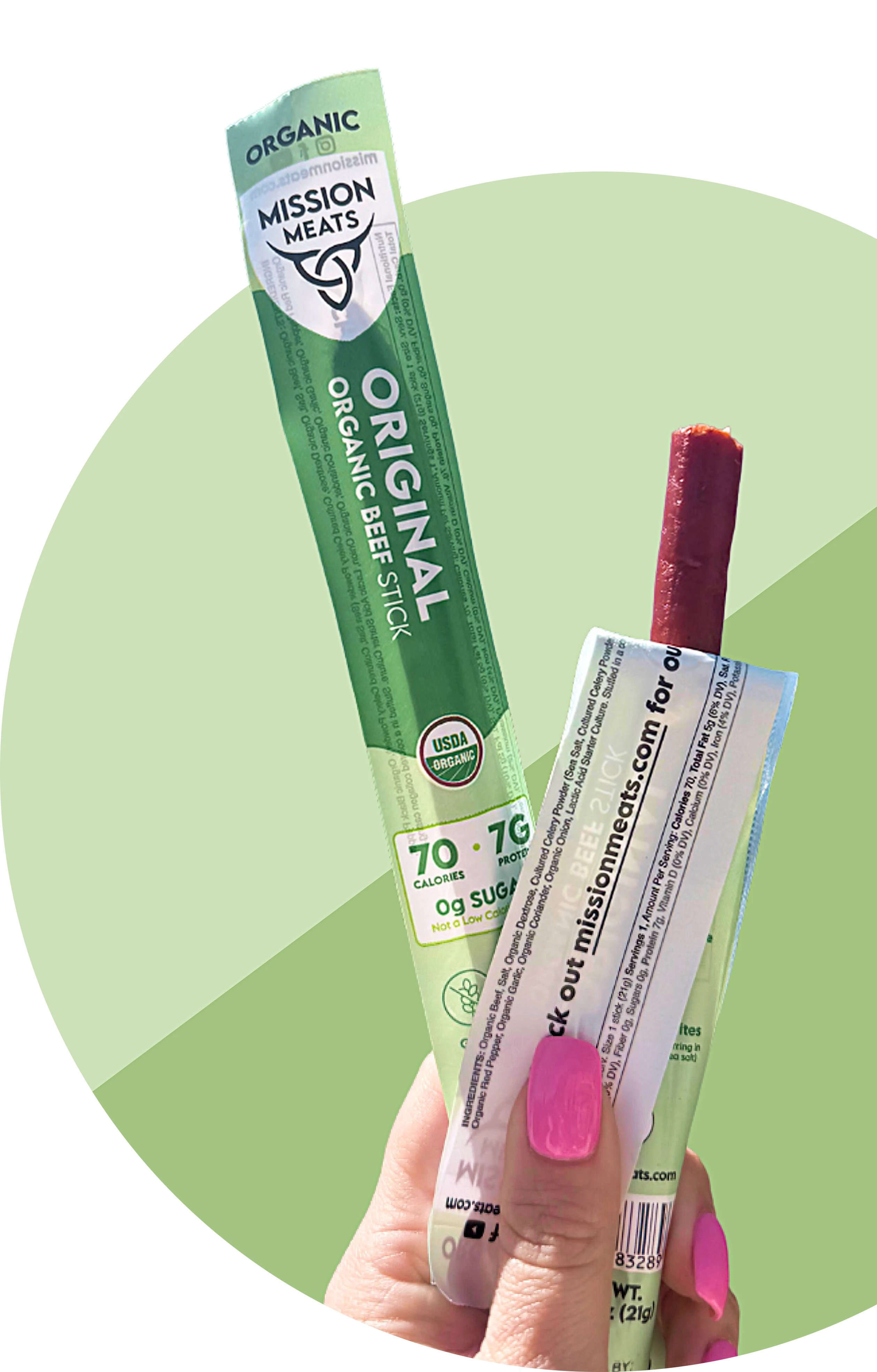 Hand holding an organic beef stick with green packaging.