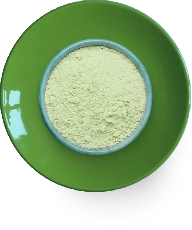Green powder in a blue bowl on a green plate.